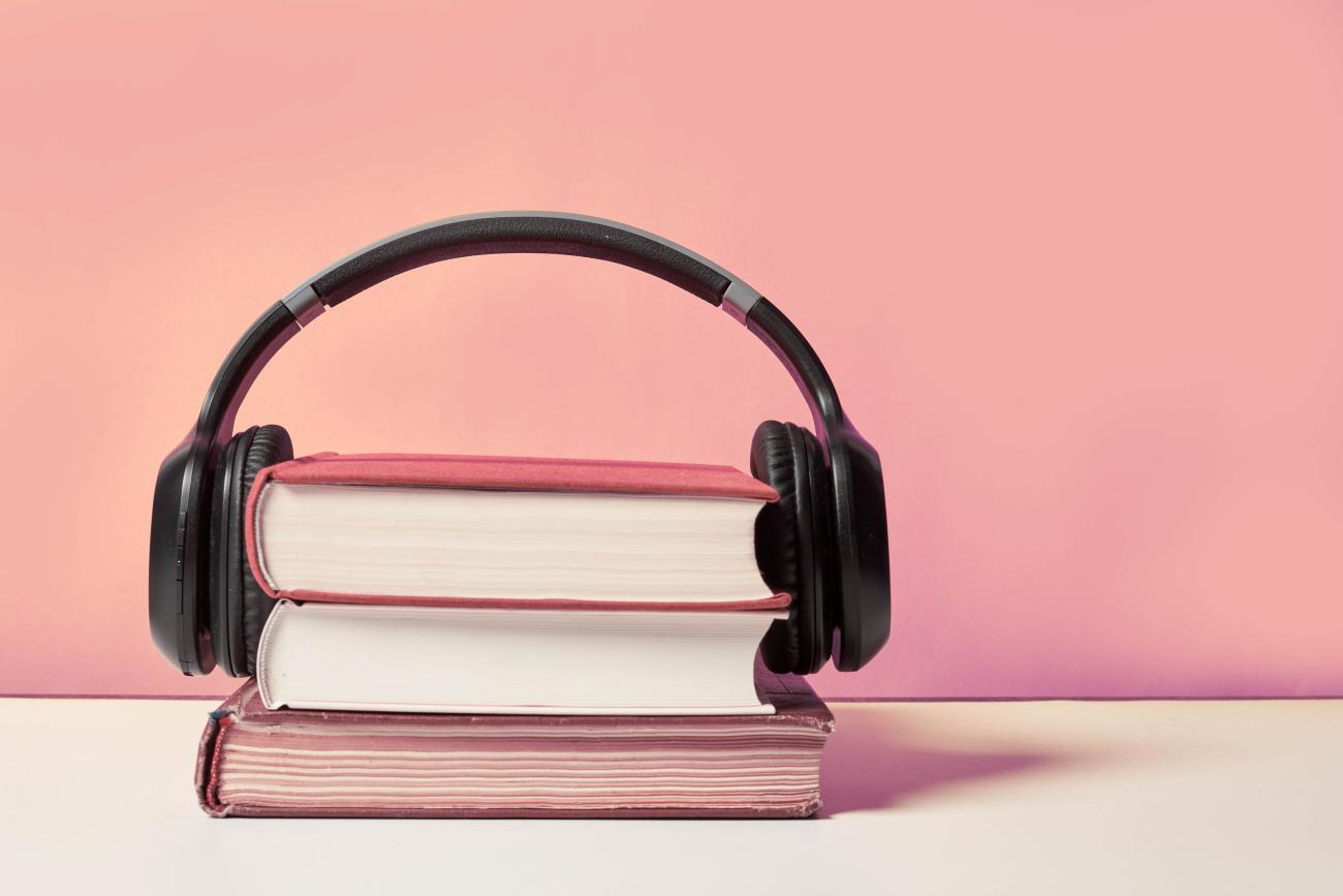 Image of a stack of books wearing headphones. Credit Marco Verch Professional Photographer on Flickr. Used under CC 2.0