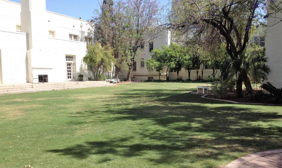 A whitewashed building and the chimney, stage and stairs viewable from inside the Secret Garden. Photo by Marilyn Arevalo/ASU.
